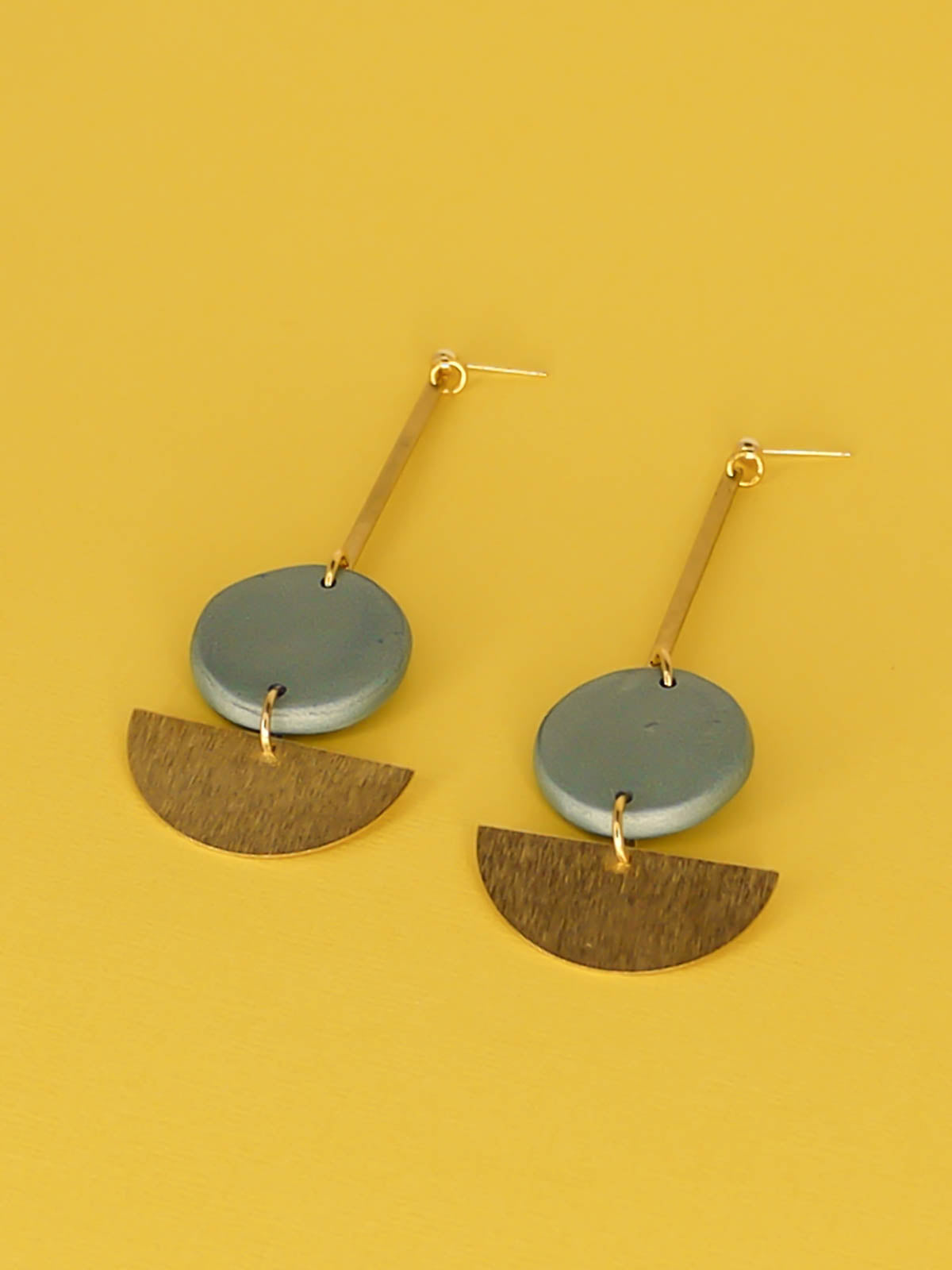 Dangle geometric statement earrings with a gold plated ball stud, a brass stick with a polymer clay round metallic circle in turquoise connected to a textured brass semi circle