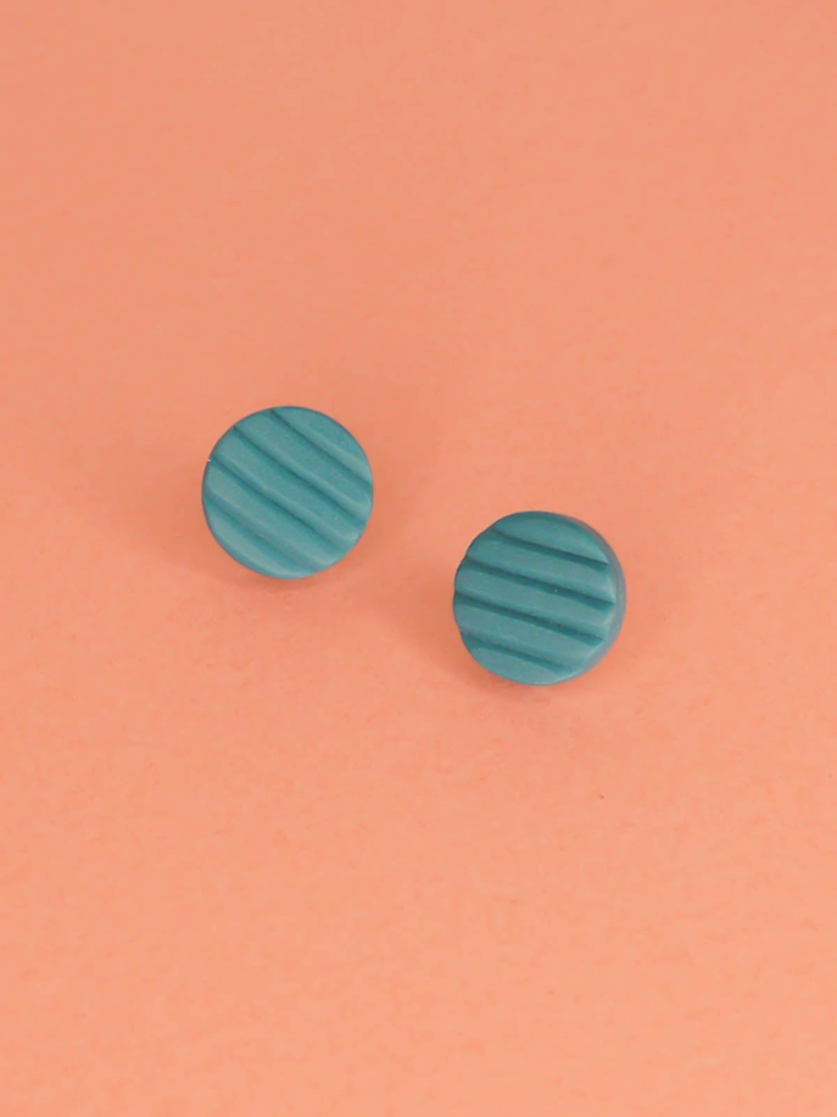 Mini turquoise polymer clay studs in a textured stripe