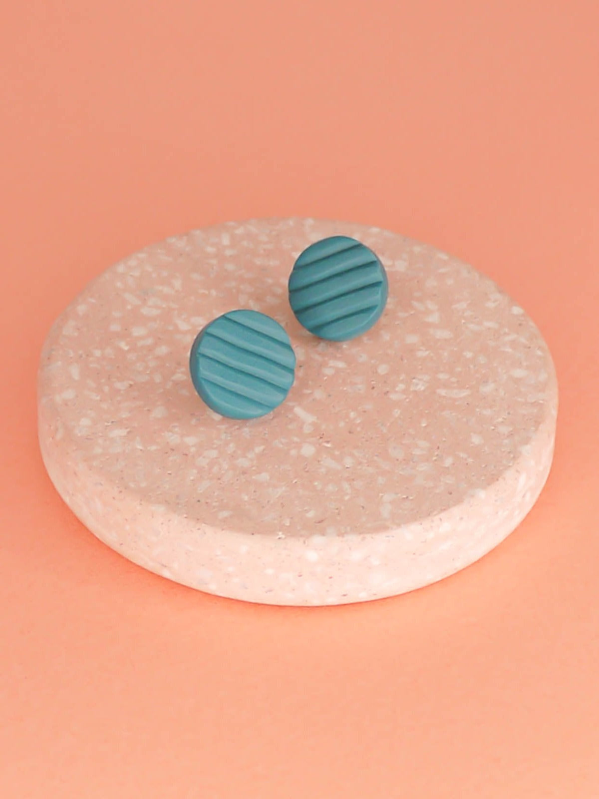 Mini turquoise polymer clay studs in a textured stripe