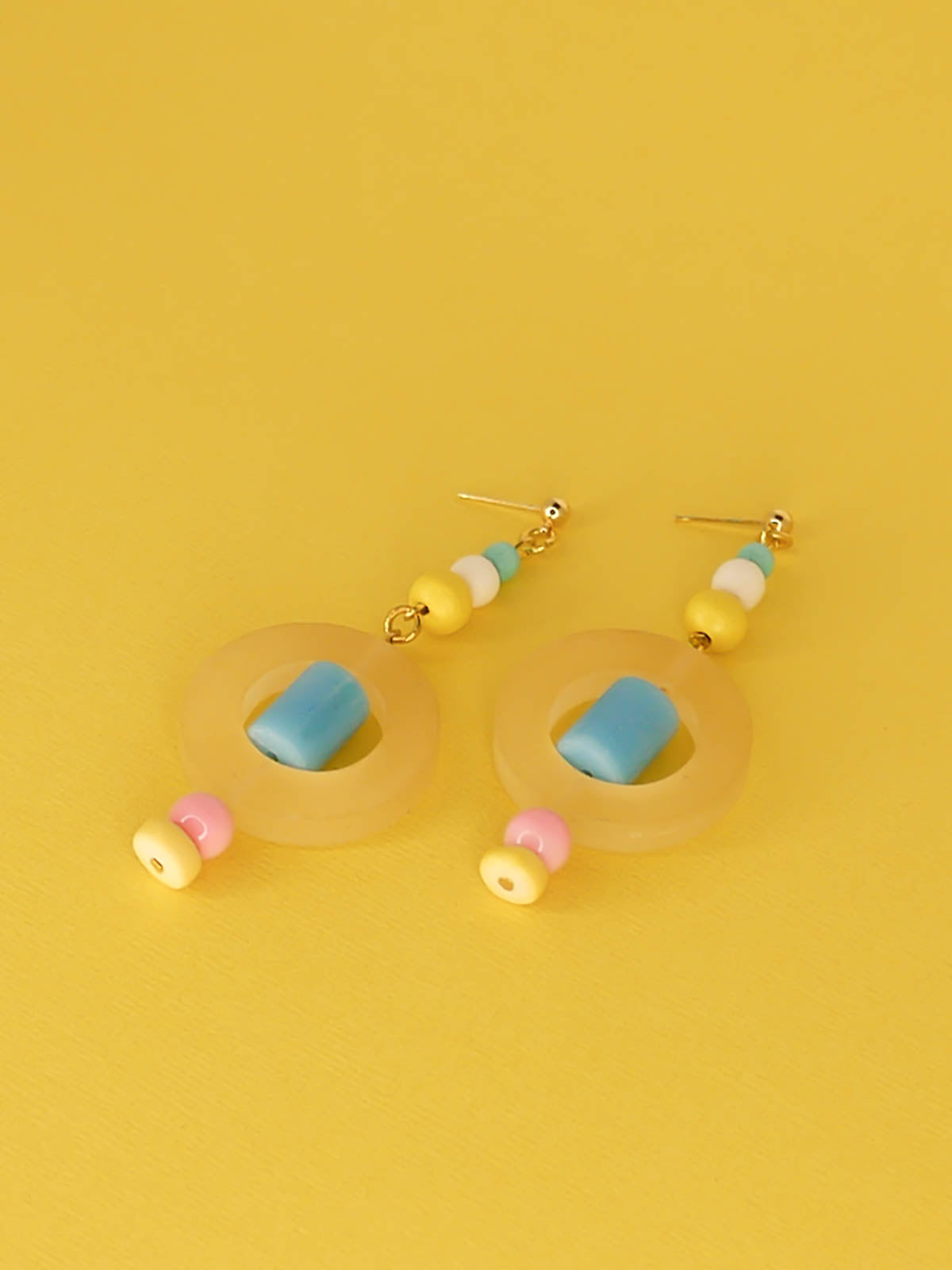 Colourful lightweight hoop bead earrings with glass & wood beads in yellow, pink & turquoise with a resin yellow hoop in the centre & a resin blue tube bead in the middle. Hung from 24k gold plated ball studs.